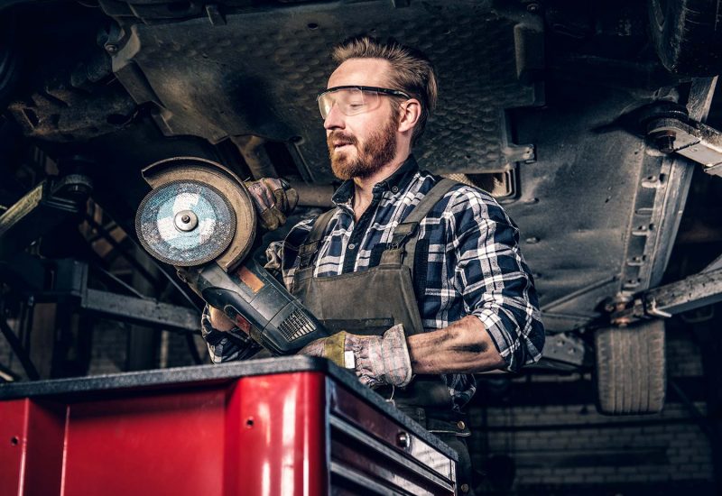 mechanic-in-protective-googles-holds-angle-grinder-small