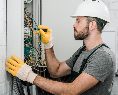 side-view-of-handsome-bearded-electrician-repairin-resize