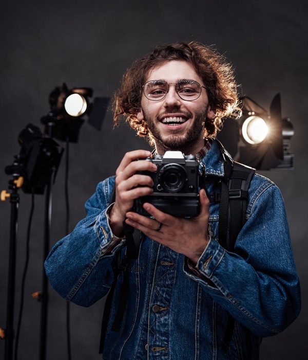 young-photographer-holds-a-camera-studio-portrait-resize