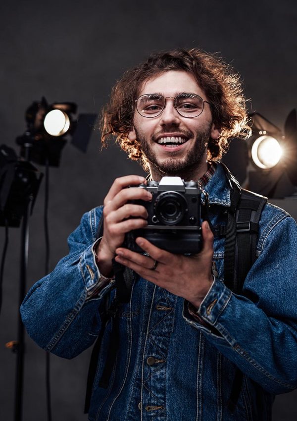 young-photographer-holds-a-camera-studio-portrait-resize